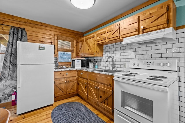 kitchen featuring light stone countertops, light hardwood / wood-style floors, white appliances, backsplash, and sink