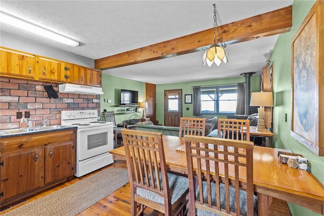 kitchen with beam ceiling, light hardwood / wood-style floors, white electric stove, and pendant lighting