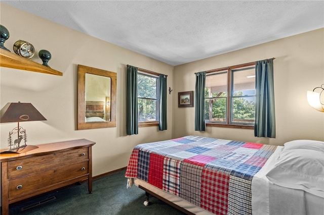 bedroom with a textured ceiling and dark carpet