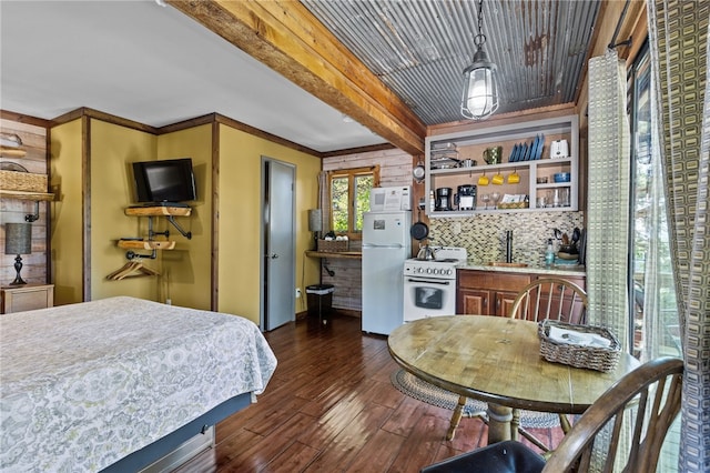 bedroom with dark hardwood / wood-style floors, wooden walls, beam ceiling, and white fridge