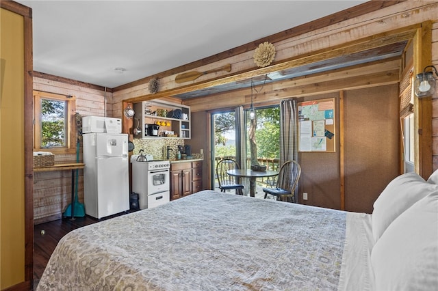 bedroom featuring white refrigerator, wood walls, and dark wood-type flooring