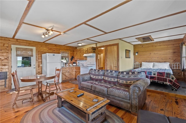 living room with hardwood / wood-style floors and wooden walls