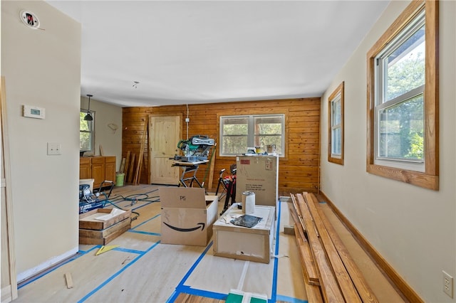 interior space with a wealth of natural light, wood walls, and light wood-type flooring