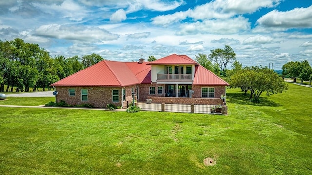 view of front of house with a balcony and a front lawn