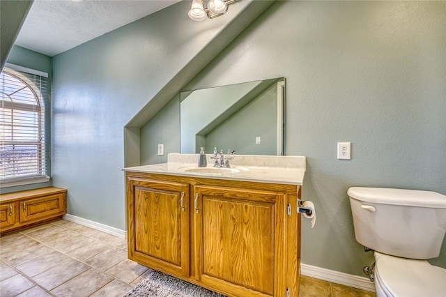 bathroom featuring tile patterned floors, vanity, a textured ceiling, and toilet