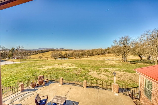 view of yard featuring a patio area, a mountain view, and a rural view