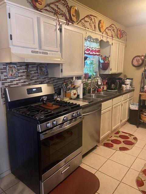 kitchen with appliances with stainless steel finishes, tasteful backsplash, light tile patterned floors, and sink