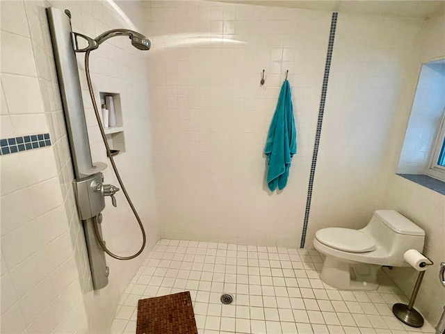 bathroom featuring a tile shower and toilet