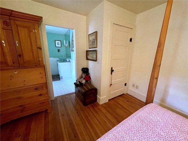 bedroom with ensuite bathroom and dark hardwood / wood-style floors