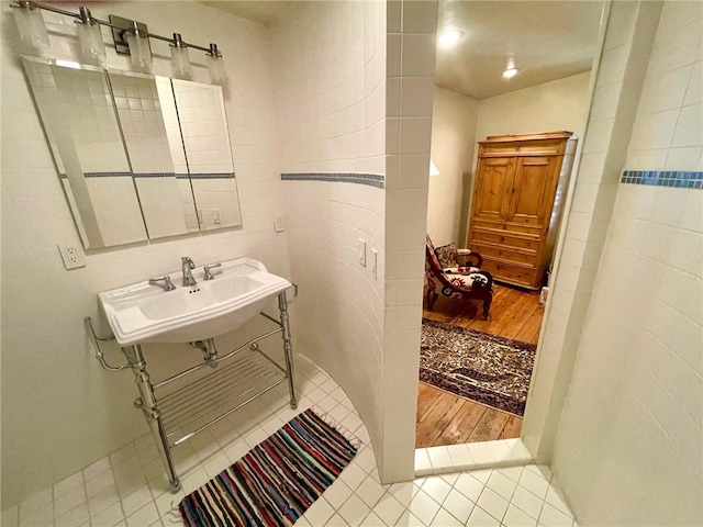 bathroom featuring tile walls, sink, and hardwood / wood-style floors