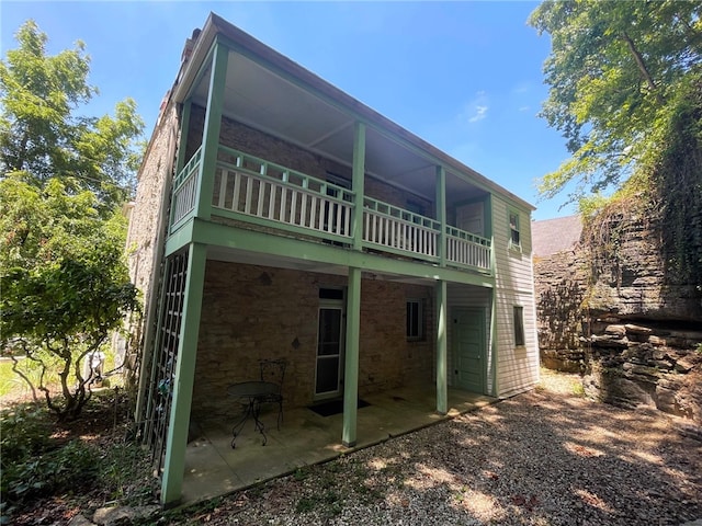 rear view of house with a patio and a balcony