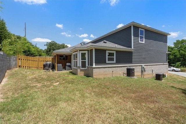 back of property with a yard and central AC unit