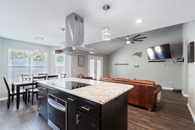 kitchen featuring island exhaust hood, black electric stovetop, stainless steel oven, hanging light fixtures, and a kitchen island