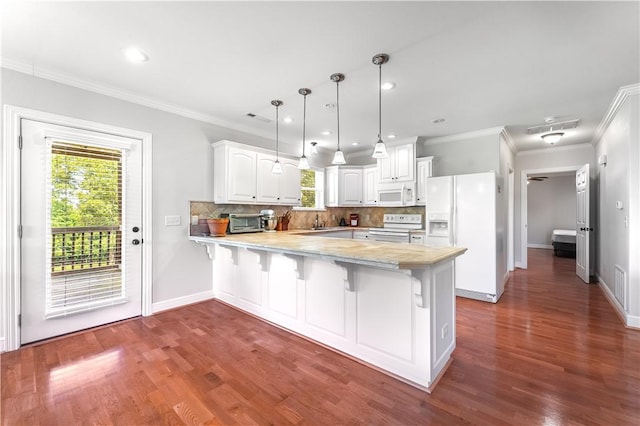 kitchen featuring hanging light fixtures, tasteful backsplash, kitchen peninsula, white appliances, and white cabinets