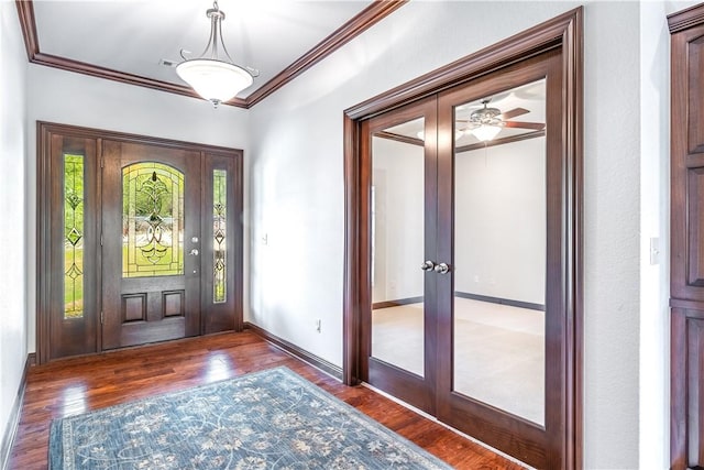 foyer featuring dark hardwood / wood-style floors, ceiling fan, ornamental molding, and french doors