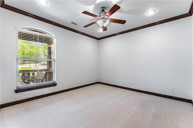 empty room featuring light carpet, ceiling fan, and crown molding