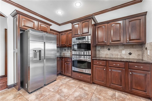 kitchen with decorative backsplash, ornamental molding, stainless steel appliances, light tile patterned floors, and dark stone countertops