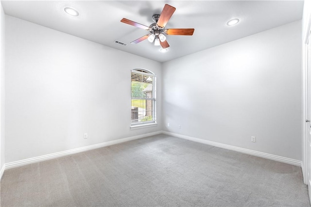 spare room with ceiling fan and light colored carpet