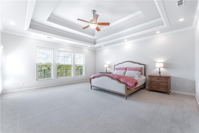 carpeted bedroom with ceiling fan, a raised ceiling, and ornamental molding