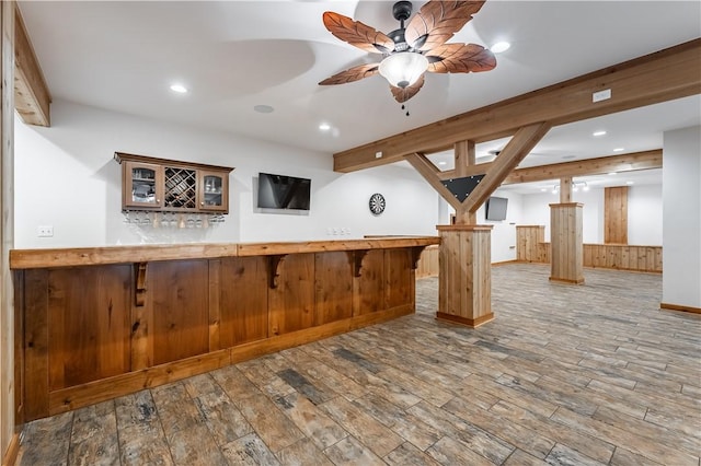 kitchen featuring hardwood / wood-style floors, ceiling fan, kitchen peninsula, a breakfast bar area, and decorative columns