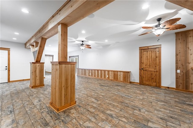 interior space featuring wooden walls, ceiling fan, and wood-type flooring