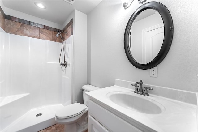 bathroom featuring vanity, toilet, and walk in shower