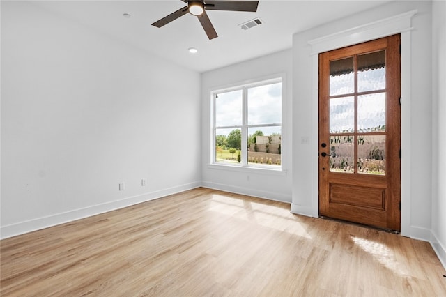 foyer entrance featuring light wood-type flooring, ceiling fan, and a wealth of natural light