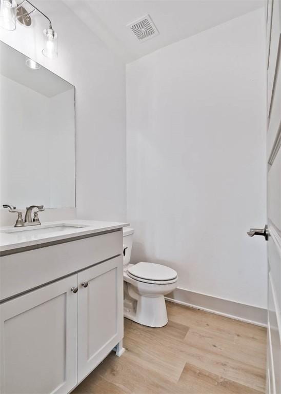 bathroom featuring hardwood / wood-style floors, vanity, and toilet