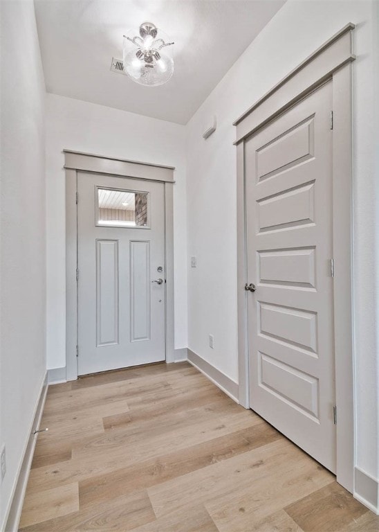 entrance foyer with light wood-type flooring and an inviting chandelier