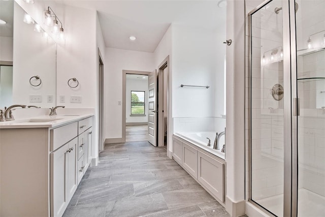 bathroom featuring shower with separate bathtub and vanity