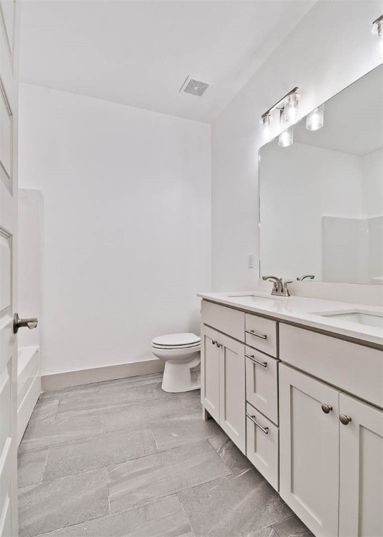 bathroom with hardwood / wood-style flooring, vanity, and toilet