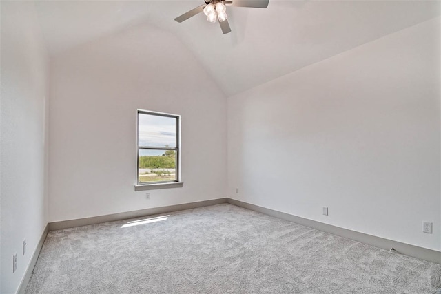 carpeted spare room with ceiling fan and vaulted ceiling