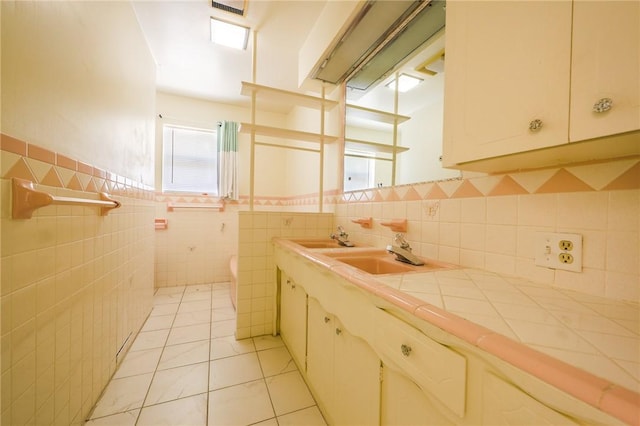 bathroom with sink, tile walls, and tile patterned floors