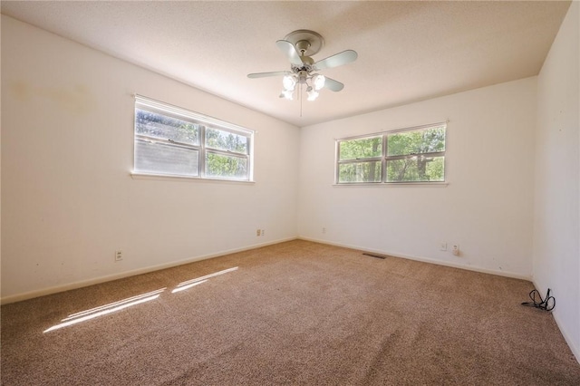 carpeted spare room featuring ceiling fan