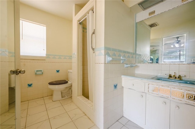 bathroom featuring toilet, vanity, tile walls, tile patterned floors, and a shower