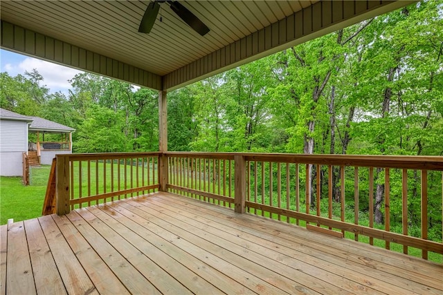 wooden terrace featuring a yard and ceiling fan