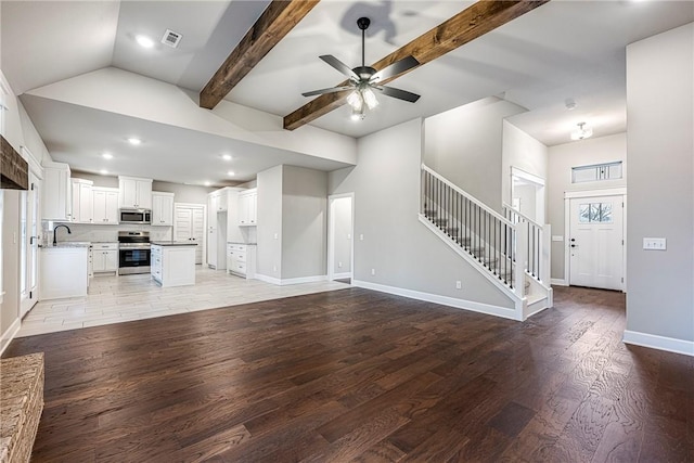 32 Taransay Dr, Bella Vista, AR 72715 - unfurnished living room featuring visible vents, light wood-style flooring, stairs, a ceiling fan, and a sink