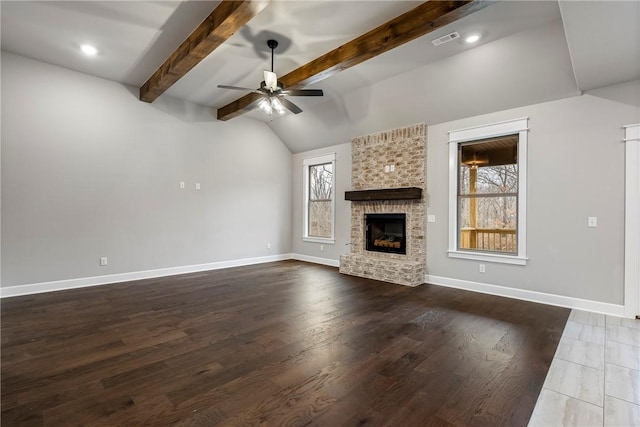 unfurnished living room with baseboards, visible vents, lofted ceiling with beams, wood finished floors, and a brick fireplace