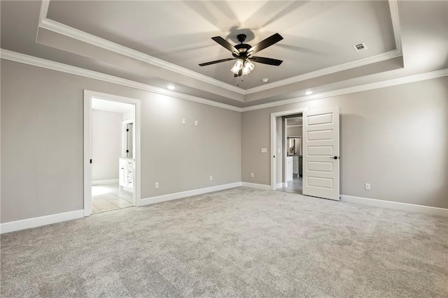 unfurnished room with baseboards, a tray ceiling, a ceiling fan, and light colored carpet