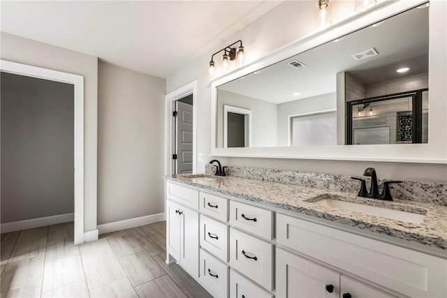 bathroom with double vanity, a stall shower, a sink, and visible vents