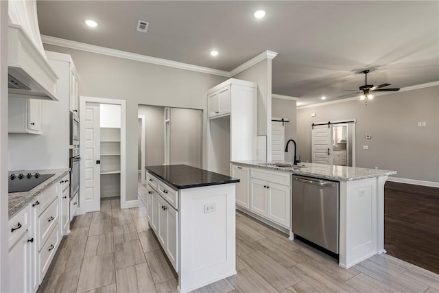 kitchen featuring a barn door, a sink, visible vents, appliances with stainless steel finishes, and custom exhaust hood