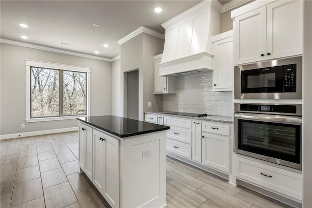 kitchen featuring crown molding, custom exhaust hood, decorative backsplash, white cabinets, and black appliances