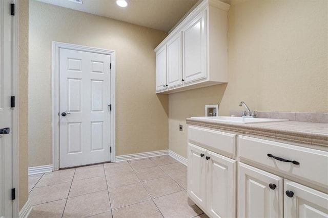 laundry area with sink, cabinets, washer hookup, electric dryer hookup, and light tile patterned floors