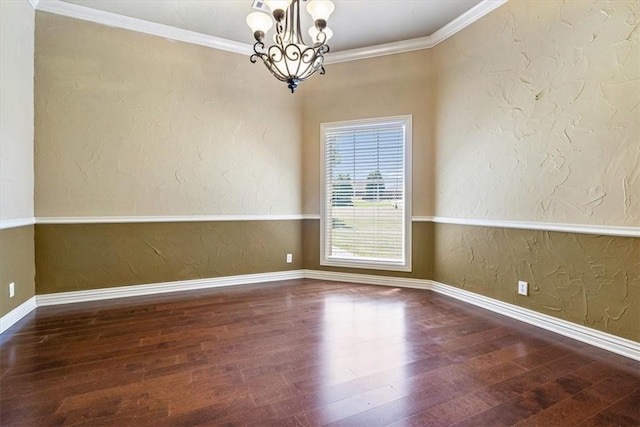 spare room with dark hardwood / wood-style flooring, ornamental molding, and a chandelier