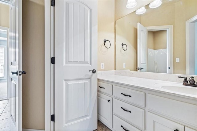 bathroom with tile patterned floors, a shower, and vanity