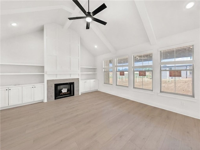 unfurnished living room with light wood-style floors, ceiling fan, beam ceiling, and a fireplace
