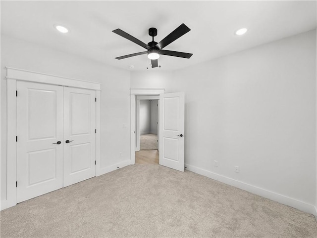 unfurnished bedroom with light colored carpet, a closet, baseboards, recessed lighting, and a ceiling fan