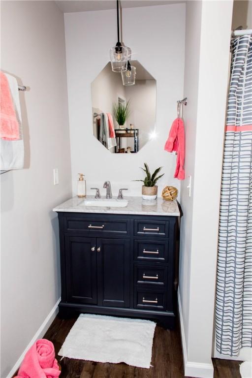 bathroom with baseboards, wood finished floors, and vanity