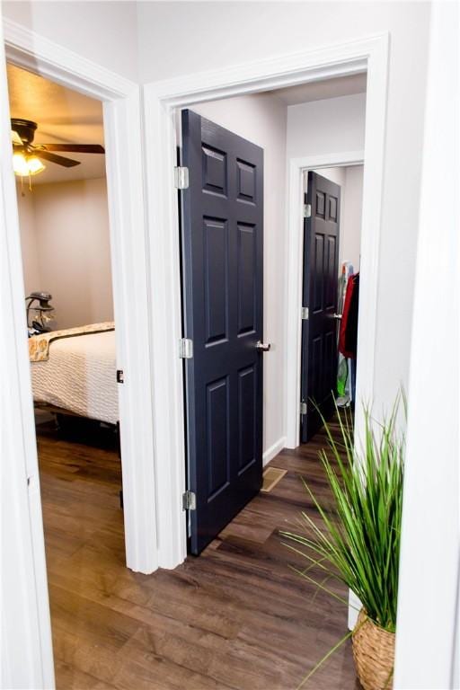 hall with baseboards and dark wood-style flooring