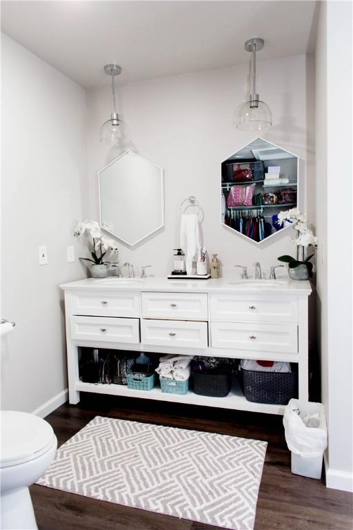 bathroom with dual vanity, hardwood / wood-style floors, and toilet